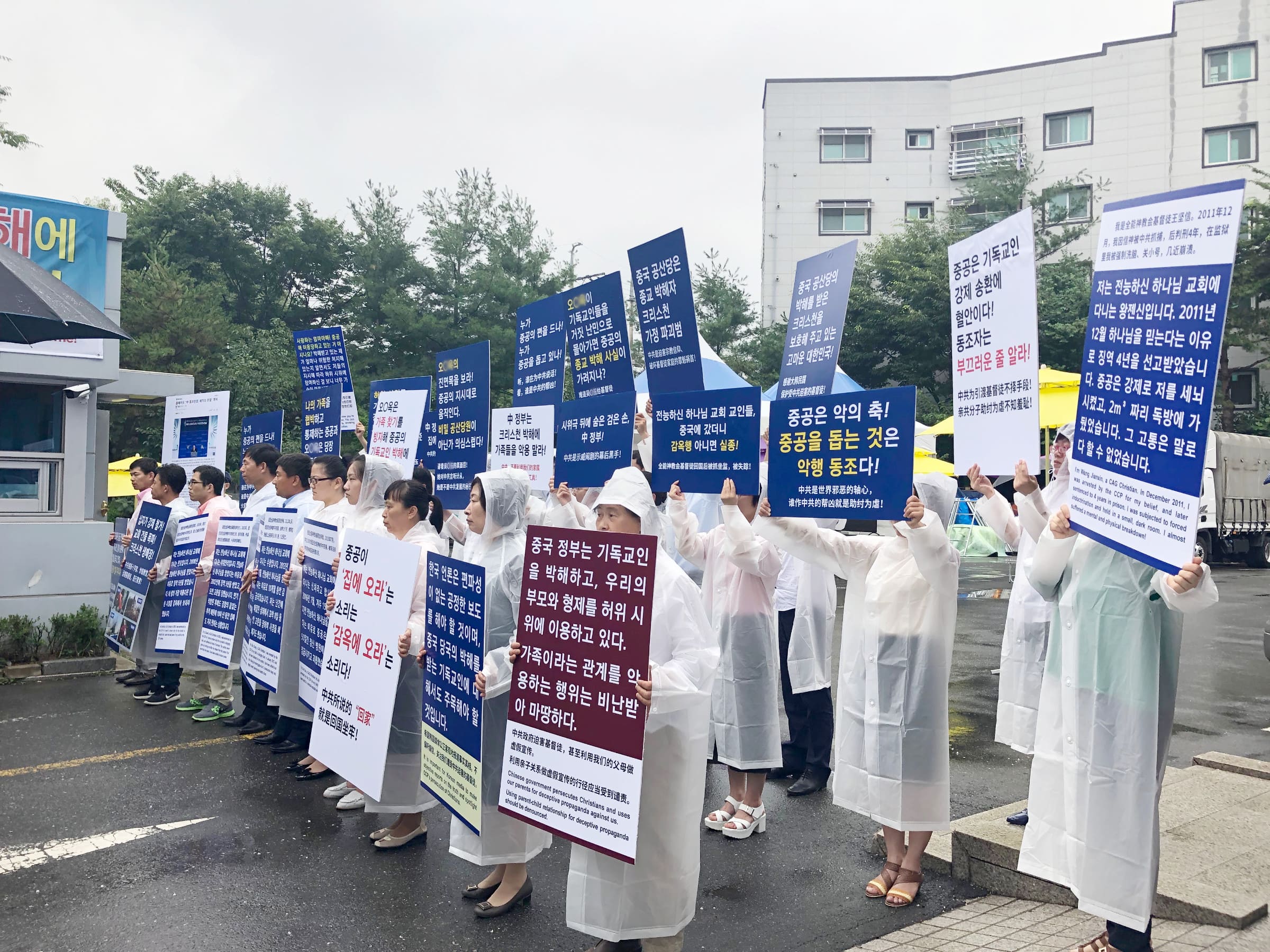 全能神教会基督徒在温水全能神教会门口举牌，抗议中共利用家属来韩假示威（图：向明）