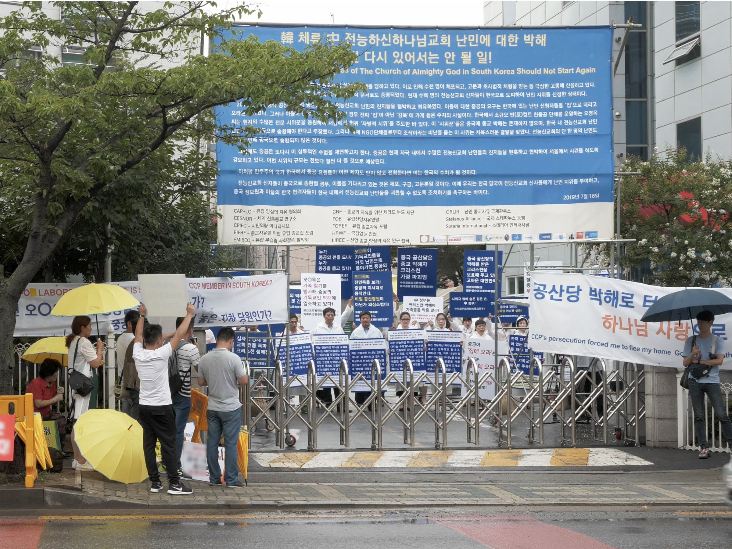 全能神教会基督徒在温水全能神教会门口举牌，抗议中共利用家属来韩假示威（图：向明）