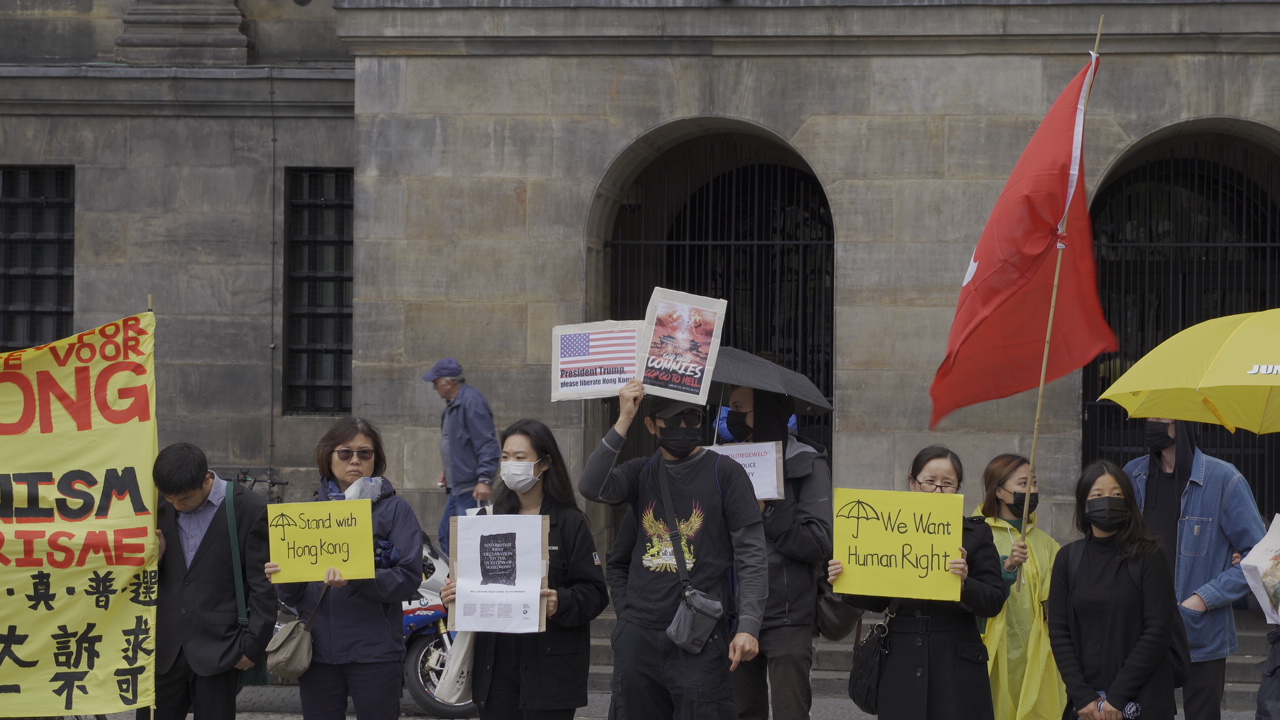 守护民主荷港同行”集会现场，与会者手持标语牌支持香港民主运动