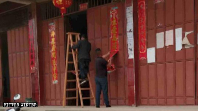 余干县政府人员正在撕毁带有十字架的对联