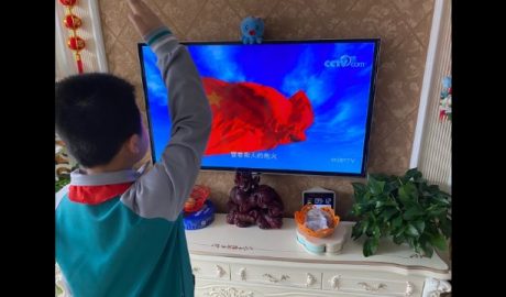 山东胶州小学生在家通过电视机上网课观看升国旗并敬礼
