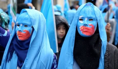 维吾尔人戴着讽刺中国打压维吾尔族人的面具示威