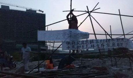 中国广东的一名农民在被拆迁的自家住宅原址搭建竹棚居住