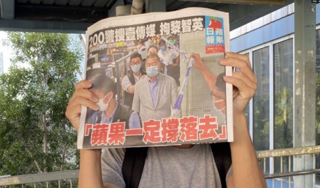 市民在天水围西铁站外领取8月11日的免费苹果日报，高举头版以示支持。