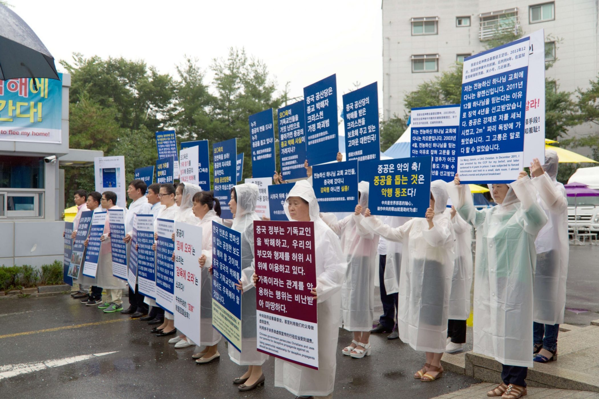 全能神教会基督徒在温水全能神教会门口举牌，抗议中共利用家属来韩假示威（图：向明）